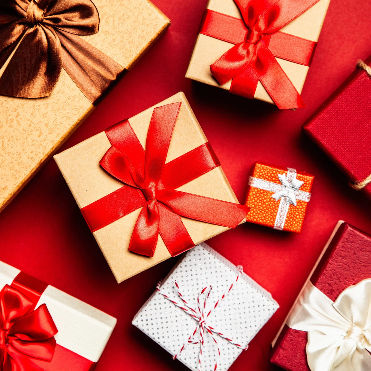 Colorful gift boxes with ribbons on a red background, perfect for donations or special occasions.